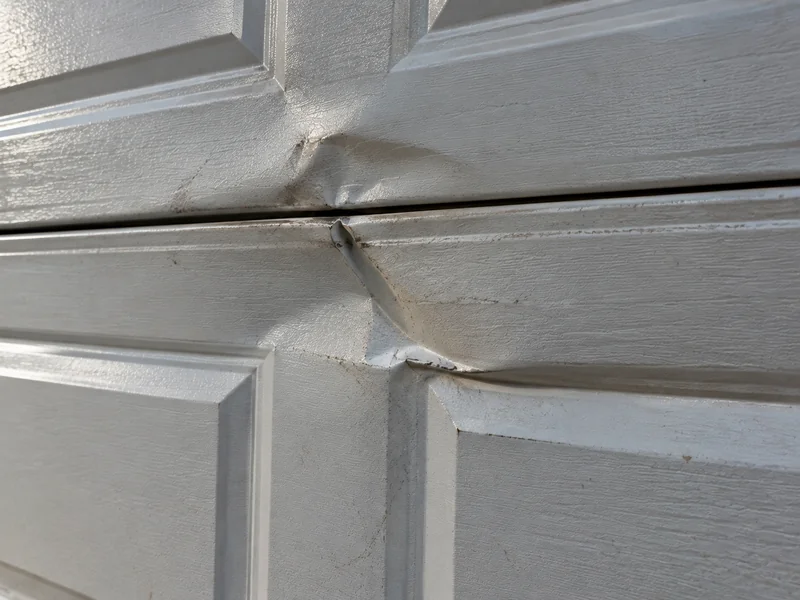 Dented steel garage door panel